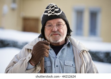 Senior Man In Warm Clothing Holding Snow Shovel