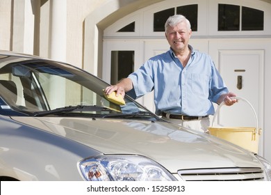 Senior Man Washing Car With Sponge