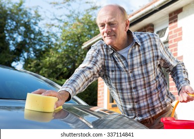 Senior Man Washing Car With Sponge