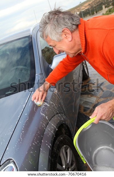 Senior man washing his\
car