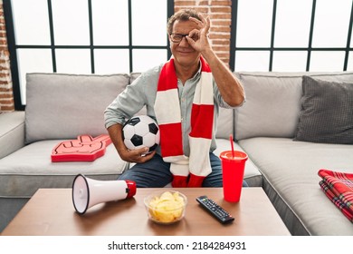 Senior Man Watching Football Holding Ball Supporting Team Smiling Happy Doing Ok Sign With Hand On Eye Looking Through Fingers 