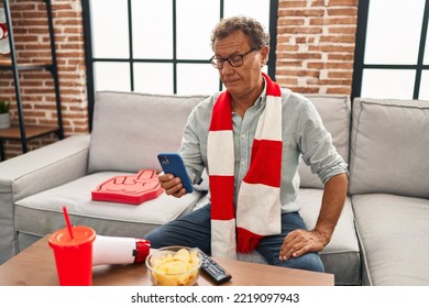 Senior Man Watching Football Looking At Smartphone Thinking Attitude And Sober Expression Looking Self Confident 