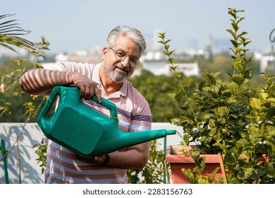 Senior man watering the flowers in the garden. - Powered by Shutterstock