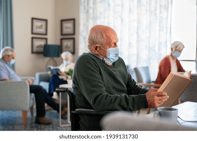 Senior man wearing face mask and reading a book at nursing home. Old disabled man sitting on wheelchair reading book during covid-19 pandemic. Elder wearing surgical mask and reading during lockdown. - Powered by Shutterstock