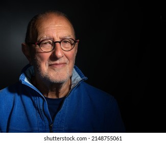 Senior Man Wearing Glasses On Plain Dark Background With Copy Space