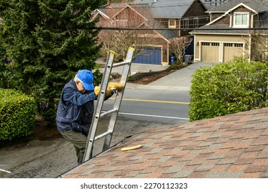 Senior man wearing leather work gloves climbing an aluminum extension ladder up to a rooftop  - Powered by Shutterstock