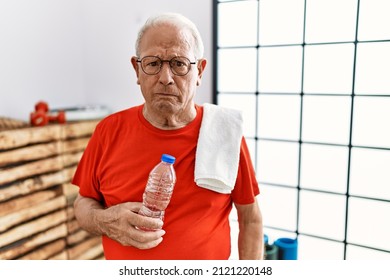 Senior Man Wearing Sportswear And Towel At The Gym Depressed And Worry For Distress, Crying Angry And Afraid. Sad Expression. 