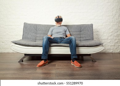 Senior Man Wearing Vr Glasses, Sitting On Couch - Shutterstock ID 551289970