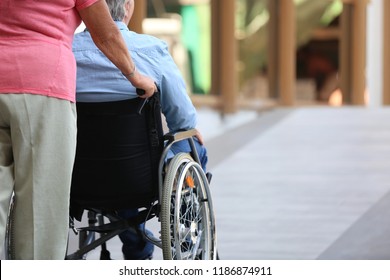 Senior Man In Wheelchair And His Wife On Ramp Outdoors