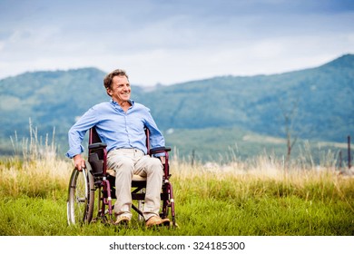 Senior Man In Wheelchair Outside In Nature