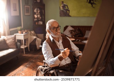 Senior man in wheelchair painting with loyal dog by his side at home - Powered by Shutterstock