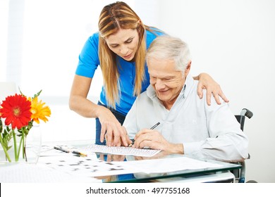 Senior Man In Wheelchair Solving Mazes As Memory Training With Help Of Daughter