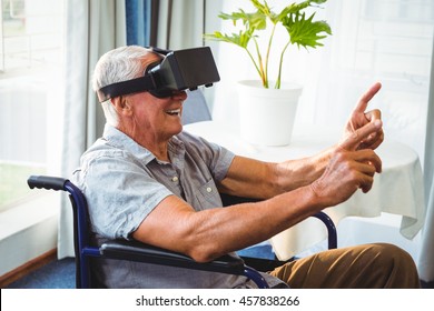 Senior man in a wheelchair using a virtual reality device in a retirement home - Powered by Shutterstock