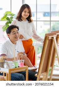 Senior Man And Woman Couple, Husband And Wife, Painting Image Together In Home Gallery With Warm And Happy Circumstance. Idea For Time-sharing And Relaxing For Older People After Retirement.