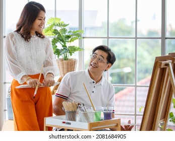 Senior Man And Woman Couple, Husband And Wife, Painting Image Together In Home Gallery With Warm And Happy Circumstance. Idea For Time-sharing And Relaxing For Older People After Retirement.