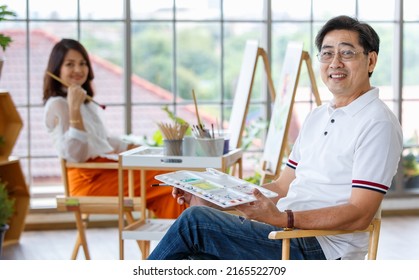 Senior Man And Woman Couple, Husband And Wife, Painting Image Together In Home Gallery With Warm And Happy Circumstance. Idea For Time-sharing And Relaxing For Older People After Retirement.