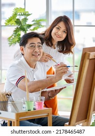 Senior Man And Woman Couple, Husband And Wife, Painting Image Together In Home Gallery With Warm And Happy Circumstance. Idea For Time-sharing And Relaxing For Older People After Retirement.