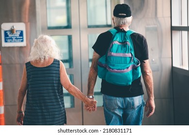 Senior Man And Woman Holding Hands. Rear View Of Old Couple Walking Hand At Subway Station In Boston.