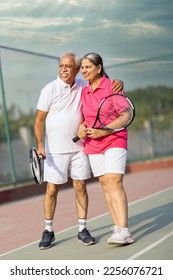 Senior man and woman hugging after playing a game of tennis at an outdoor court. - Shutterstock ID 2256076721