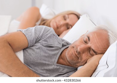 Senior man and woman sleeping. Senior man and woman resting with eyes closed. Mature couple sleeping together in their bed.