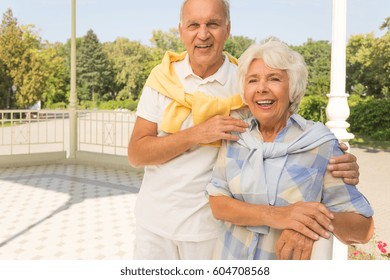 Senior Man And Woman Standing At Gazebo In Summer Day