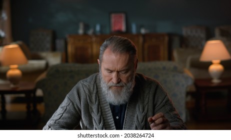 Senior Man Working With Document At Home. Serious Elderly Man Reading Letter In Luxury Living Room. Old Business Man Sitting At Table With Important Paper In Vintage Interior. 