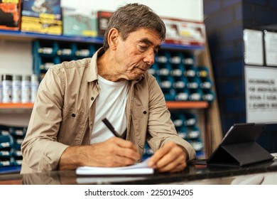 Senior man working at his hardware store. Small business concept. - Shutterstock ID 2250194205