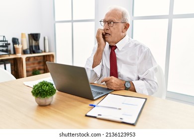 Senior Man Working At The Office Using Computer Laptop Looking Stressed And Nervous With Hands On Mouth Biting Nails. Anxiety Problem. 