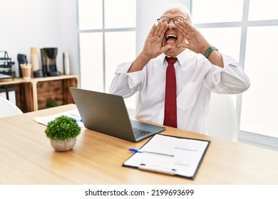 Senior Man Working At The Office Using Computer Laptop Smiling Cheerful Playing Peek A Boo With Hands Showing Face. Surprised And Exited 