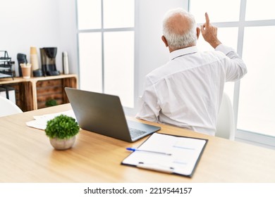 Senior Man Working At The Office Using Computer Laptop Posing Backwards Pointing Ahead With Finger Hand 