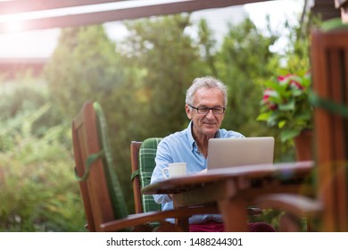 Senior Man Working On Laptop In The Garden
