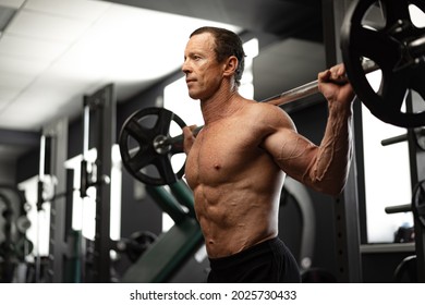 Senior man working out at the gym doing squats - Powered by Shutterstock