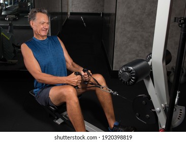 Senior Man Working Out On A Rowing Machine In The Gym