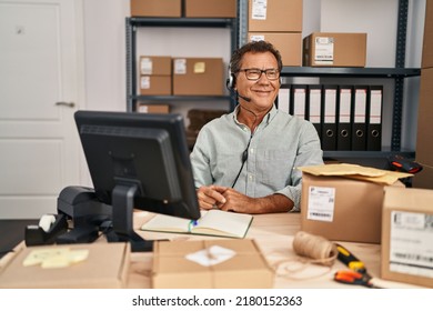 Senior Man Working At Small Business Ecommerce Wearing Headset Looking To Side, Relax Profile Pose With Natural Face And Confident Smile. 