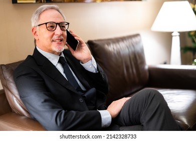 Senior Manager On The Phone Sitting On A Couch In A Hotel