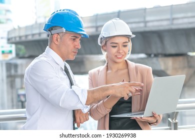 Senior Manager And Woman Worker With Safety Helmet Meeting Seeing Laptop Brainstorm Working Outside A Factory