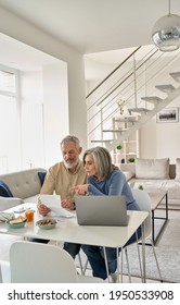 Senior Mature Couple Check Bank Loan Documents Using Laptop At Home. Middle Aged Old Family Read Paper Bills Payments, Calculating Pension Or Taxes, Planning Retirement Finances, Household Expenses.