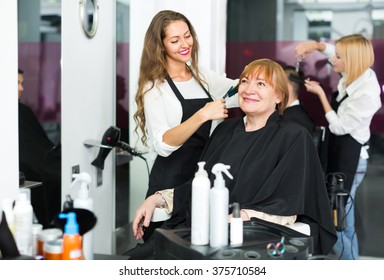 Senior Mature Woman Cutting Her Hair At The Hairdressing Salon
