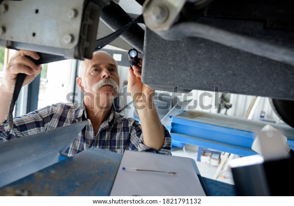senior mechanic inspecting\
for leaks