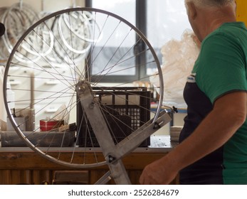 Senior mechanic mounts a tire on a wheel in a small bicycle repair shop, showcasing precision and quality with vintage tools - Powered by Shutterstock