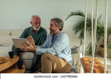 Senior men enjoying afternoon at home and using digital tablet - Shutterstock ID 1647980686