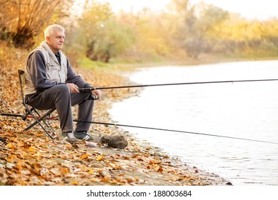 Senior Men Fishing By The Lake.