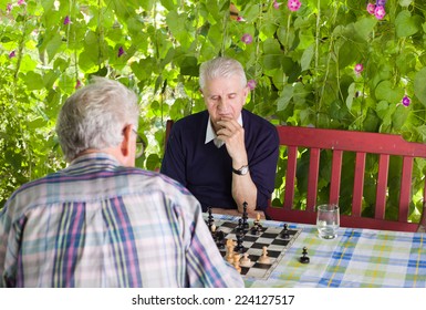 Senior Men Playing Chess In The Courtyard