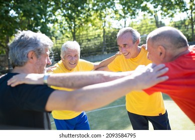 Senior Men Team Building On Summer Day. Men With Grey Hair In Sport Clothes Standing In Circle On Sport Field. Football, Sport, Leisure Concept