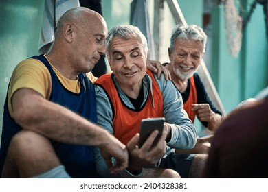 Senior men using smartphone in locker room - Powered by Shutterstock