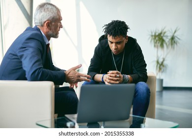 Senior Mental Health Professional Talking To Depressed African American Adolescent During Psychotherapy At Counselling Center. 