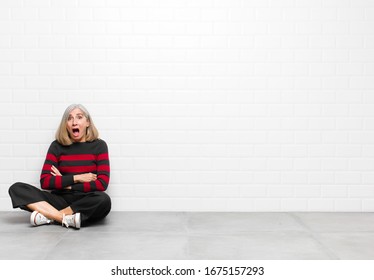 senior middle age pretty woman feeling terrified   shocked  and mouth wide open in surprise