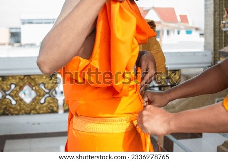 The senior monk  wearing a yellow robe to new monk . Buddhist ordination ceremony in the temple, Thailand