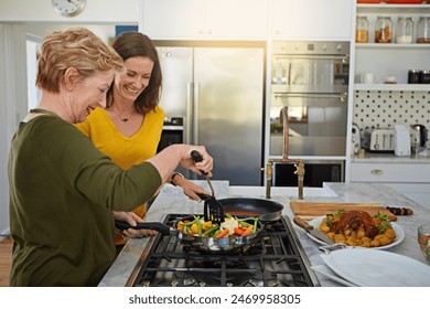 Senior mother, daughter and cooking in kitchen with laughing, bonding and healthy meal with funny joke in home. Family, woman and happy with helping, support and teaching with vegetables or nutrition - Powered by Shutterstock