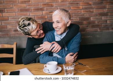 Senior Mother Sitting In Cafe Bar Or Restaurant With Her Middle Aged Daughter And Enjoying In Conversation. 